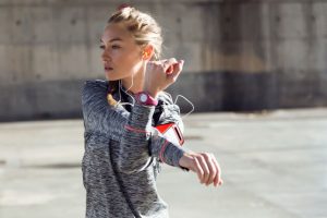 The woman stretches her arms while listening to music.