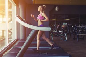 The woman has a regular exercise on the treadmill.