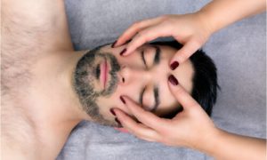 A man receiving facial massage.